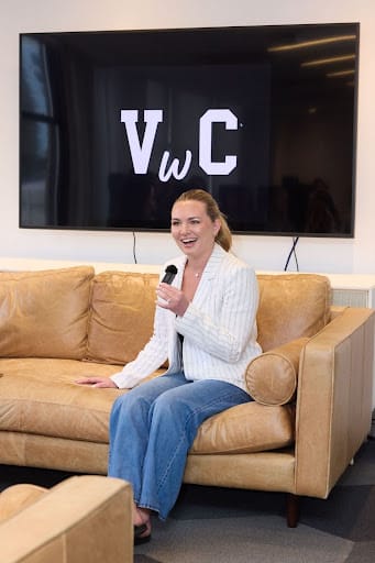 A speaker holding a microphone during a Varsity Women's Club fireside chat